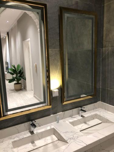 a bathroom with two sinks and a large mirror at شاليهات بالي ان الفندقية in Jeddah