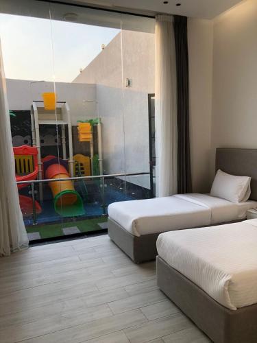 Habitación de hotel con 2 camas y un reflejo en la ventana en شاليهات بالي ان الفندقية, en Yeda