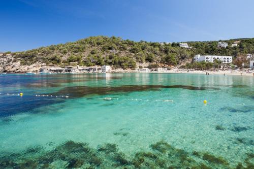 a large body of water with a beach at Aparthotel Puerto Cala Vadella in Cala Vadella
