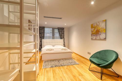 - une chambre avec des lits superposés et une chaise verte dans l'établissement Luxurious 3 Bedroom Apartment in Herastrau, à Bucarest