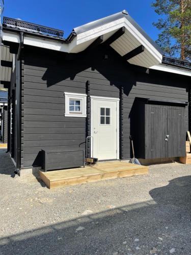 a black garage with a white door and a porch at Stuga i Vemdalen in Vemdalen