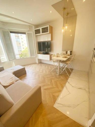 ein Wohnzimmer mit einem Sofa und einem Tisch in der Unterkunft Appartement 2P Idéalement Placé Juan les Pins in Juan-les-Pins