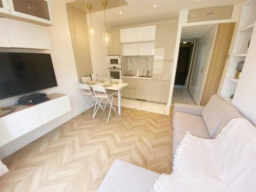 a living room with a white couch and a table at Appartement 2P Idéalement Placé Juan les Pins in Juan-les-Pins