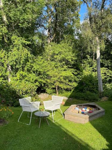 dos sillas y una mesa en un patio con una hoguera en Lantligt läge nära Göteborg och flygplatsen, en Landvetter