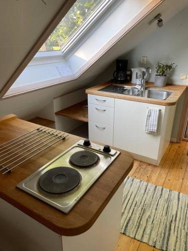 uma cozinha no sótão com um fogão e um lavatório em Lantligt läge nära Göteborg och flygplatsen em Landvetter
