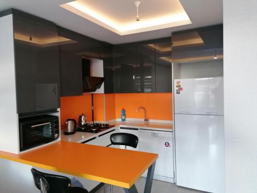 Il comprend une cuisine équipée d'un réfrigérateur blanc et d'une table. dans l'établissement Ankara Esenboğa Airport Luxury Rezidance, à Ankara