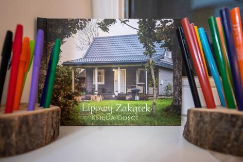 a book sitting on a table next to some pencils at Lipowy Zakątek to miejsce bez gospodarzy i na wyłączność in Siemianówka