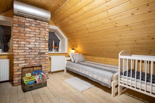 Zimmer mit einem Bett und einem gemauerten Kamin in der Unterkunft Lipowy Zakątek i Żubry na pobliskich łąkach in Siemianówka