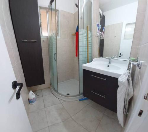 La salle de bains est pourvue d'une douche et d'un lavabo. dans l'établissement הנביאים 1 נתניה Naveim apartment, à Netanya