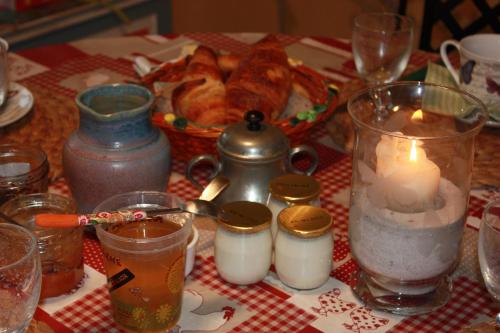 Una mesa cubierta con velas y un plato de comida. en Domaine de la Guignardière, en Viévy-le-Rayé
