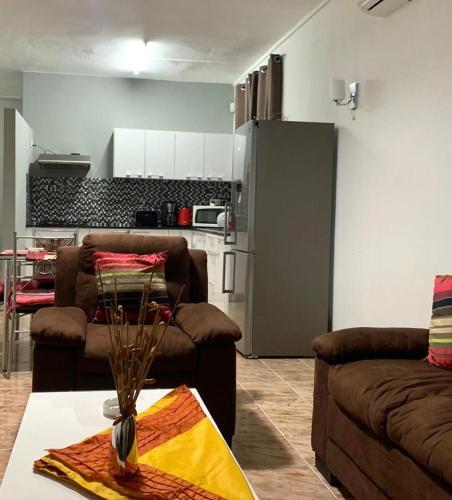 a living room with two couches and a kitchen at Sonnige Ferienwohnung mit Wifi in Flic-en-Flac