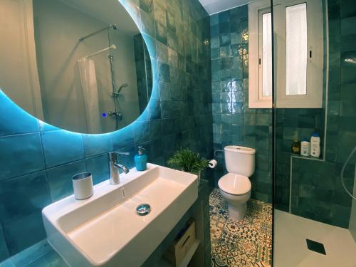 W łazience znajduje się umywalka, toaleta i lustro. w obiekcie Casa Tortilla Gracia w Barcelonie