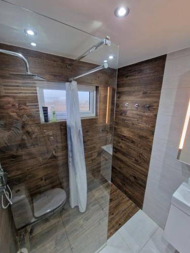 a bathroom with a shower and a toilet and a sink at R&J Guesthouse Apartment in Grindavík