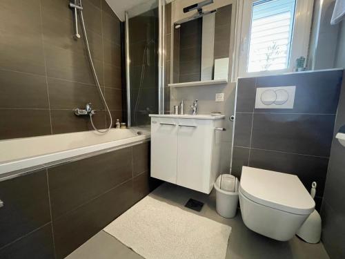 uma casa de banho com um WC, uma banheira e um lavatório. em Holiday Residence Zvono em Mlini