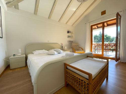 een witte slaapkamer met een bed en een raam bij Holiday Residence Zvono in Mlini