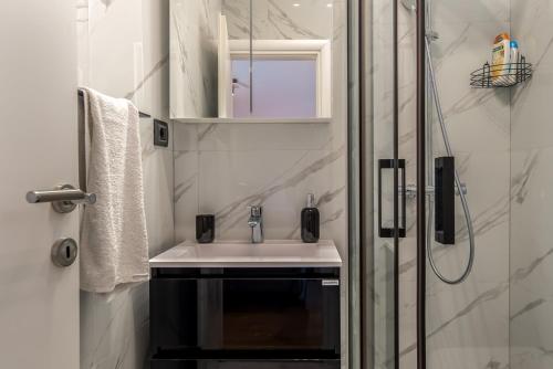 La salle de bains est pourvue d'un lavabo et d'une douche. dans l'établissement Apartment Forever, à Selce