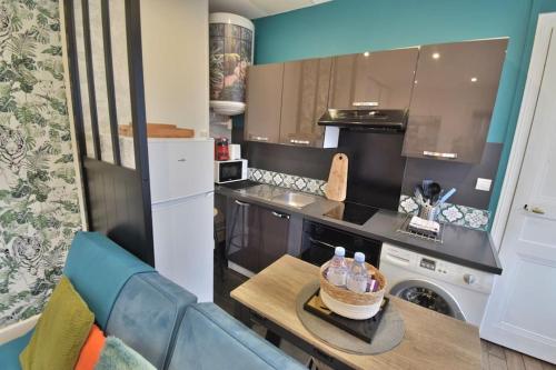 a kitchen with a table and a counter top at Superbe T2 à 200m de la Place ducale in Charleville-Mézières