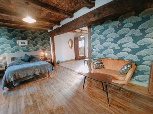 a bedroom with a bed and a chair at Chateau-une - a Beautiful historic medieval holiday rental. in Confolens
