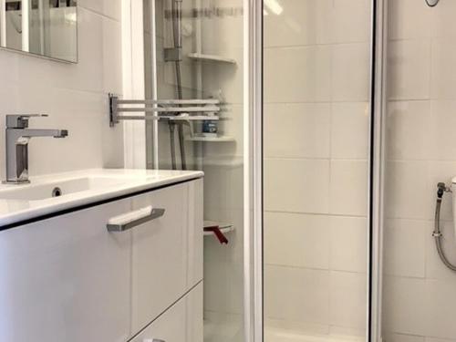 une salle de bain blanche avec une douche et un lavabo dans l'établissement Charmant 2* avec Balcon, Climatisé, Proche Thermes - FR-1-503-93, à Balaruc-les-Bains