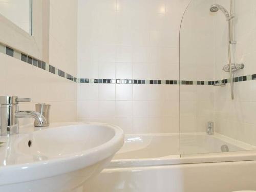 a white bathroom with a sink and a tub at Cotswolds Lake side home with luxury spa Swallows Nest,Lower Mill Estate, Lakeside home/spa in Somerford Keynes