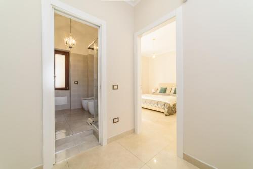 a white bedroom with a bed and a bathroom at HomeAway Salerno in Salerno