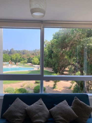 a view from a living room window with a couch at Departamento Papudo Playa Piscina in Papudo