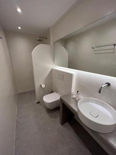 bagno bianco con lavandino e servizi igienici di Saba Luxury Suites a Karterados
