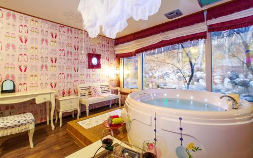 a large bathroom with a tub in a room at Casa Seorak Bed and Breakfast in Sokcho