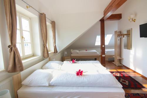 a bedroom with two beds with red bows on them at Hotel Vila Katrca in Ljubljana