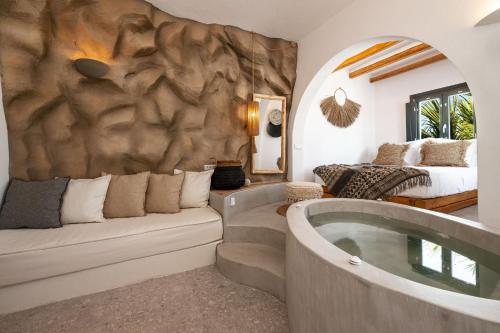 a living room with a bath tub and a bed at Sandaya Luxury Suites in Naousa