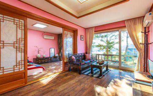 a room with pink walls and a large window at Casa Seorak Bed and Breakfast in Sokcho