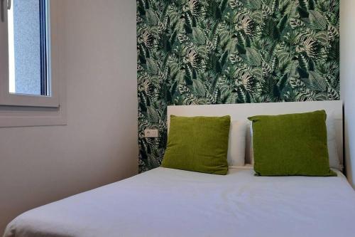 a bed with two green pillows in a bedroom at Casa rural en San Vicente de O Grove in O Grove