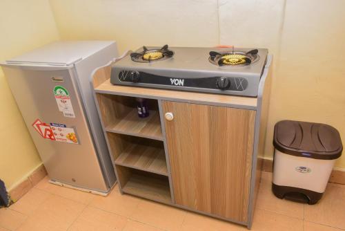 a small kitchen with a stove and a refrigerator at Leshi Place, Kinoru - Makutano, Meru in Meru