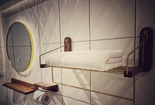 uma casa de banho com uma prateleira com toalhas e um espelho em 東海平行陸貳民宿English Friendly em Longjing