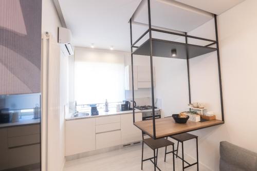 Dalmazia Boutique Apartment في كالتانيسيتا: مطبخ صغير مع طاولة وكراسي خشبية