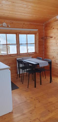 ein Esszimmer mit einem Tisch und Stühlen in einer Hütte in der Unterkunft Fálki cottages in Þórshöfn