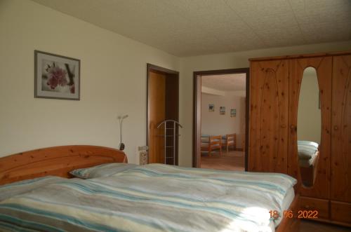 a bedroom with a bed and a wooden cabinet at Ohm in Holtsee