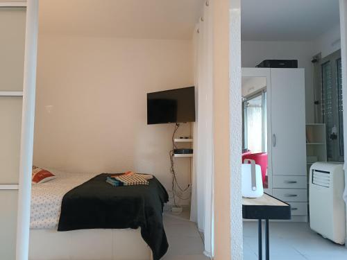 une petite chambre avec un lit et une télévision dans l'établissement Le Corinthe studio apartment, à Antibes