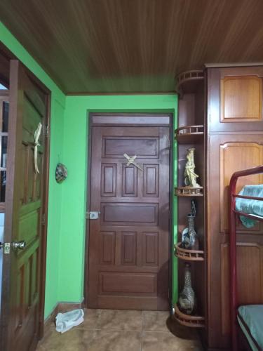 a room with a wooden door and green walls at Casa MONTOCO 114 in Managua