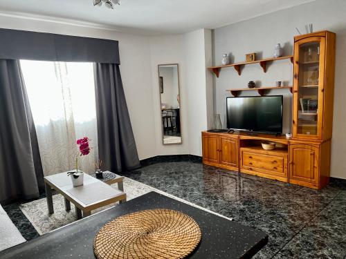 a living room with a television and a table at Apartamentos Dalia in Vecindario
