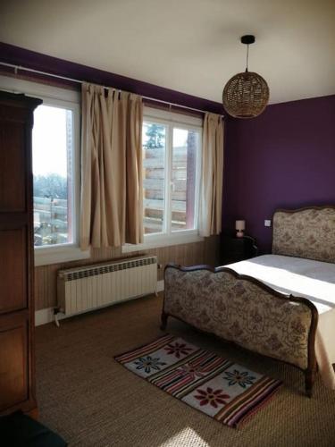 - une chambre avec des murs violets, un lit et des fenêtres dans l'établissement Maison au calme à 5 minutes du centre-ville 2 nuitées minimum, à Saint-Pourçain-sur-Sioule