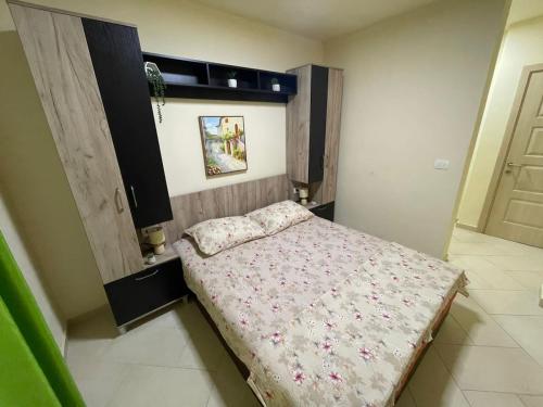 a bedroom with a bed with a floral bedspread at Apartments Pericic in Sutomore