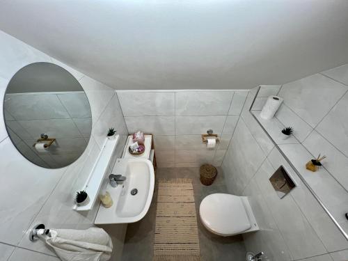 a bathroom with a sink and a toilet and a mirror at Domov nad jazerom in Banská Štiavnica