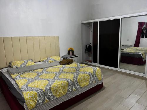 a bedroom with a bed with a yellow and blue comforter at Sunflower village villa girasoles in Jarabacoa