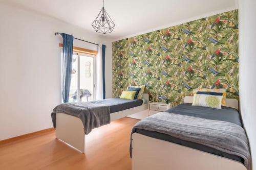 - une chambre avec 2 lits et une fresque murale dans l'établissement Nossa casa, à Peniche