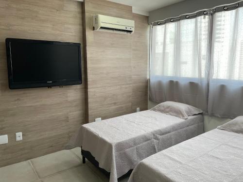 Habitación con 2 camas y TV de pantalla plana. en Flat Studio Boa Viagem, en Recife