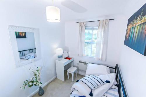 - une chambre avec un lit, un bureau et un miroir dans l'établissement Lovely apartment easy access to London, à West Thurrock