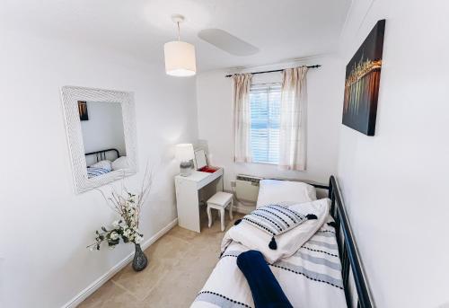 una camera con due letti e uno specchio di Lovely apartment easy access to London a West Thurrock