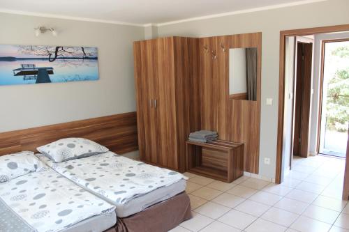 - une chambre avec un lit et une armoire en bois dans l'établissement Oaza, à Turawa