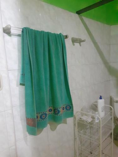 a green towel is hanging in a bathroom at Casa 114 in Managua